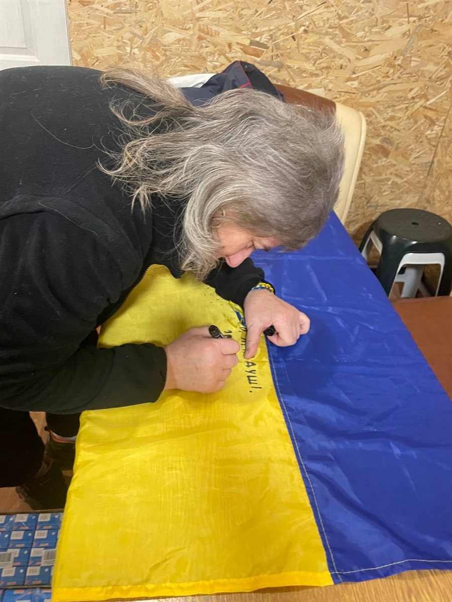 Пані Заліско підписує прапор дітям Великобурлуччини
